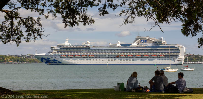 DIAMOND PRINCESS (2004 / 115875grt / IMO 9228198) sails from Auckland bound for Napier as picnickers watch from the Devonport waterfront. 24 December 2024. Photo by Â© 2024 SeapixOnline.com