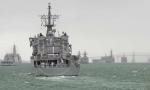 ID 10668 HMNZS OTAGO (P148) sails past the line of anchored warships in murky conditions.